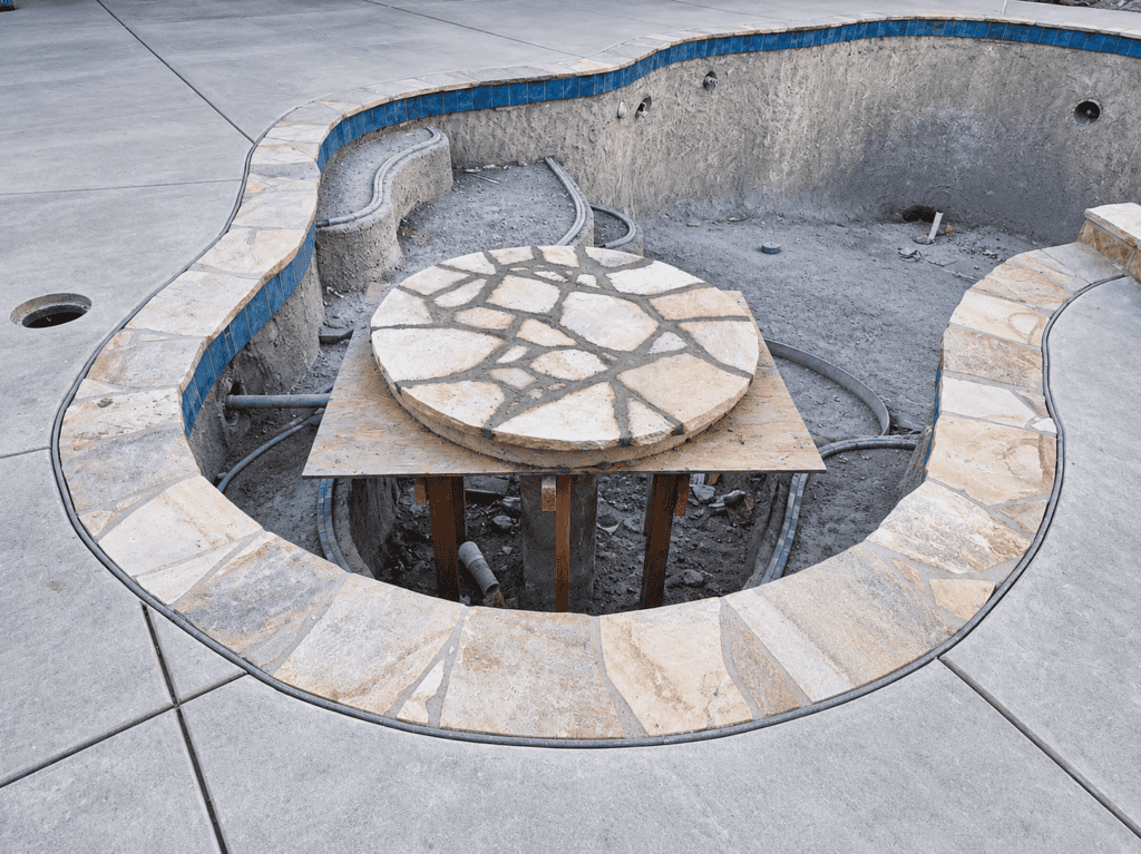 In-progress pool renovation with stone coping and interior surface.