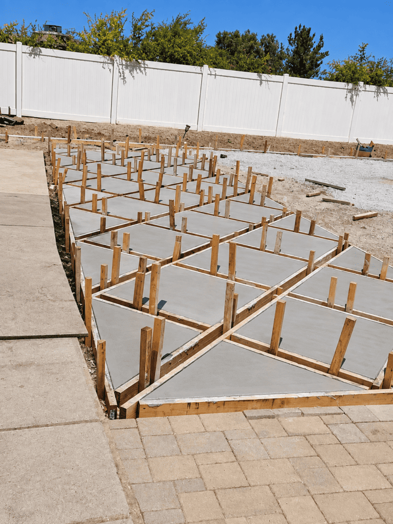 Concrete slabs with wooden forms for foundation pouring in progress.