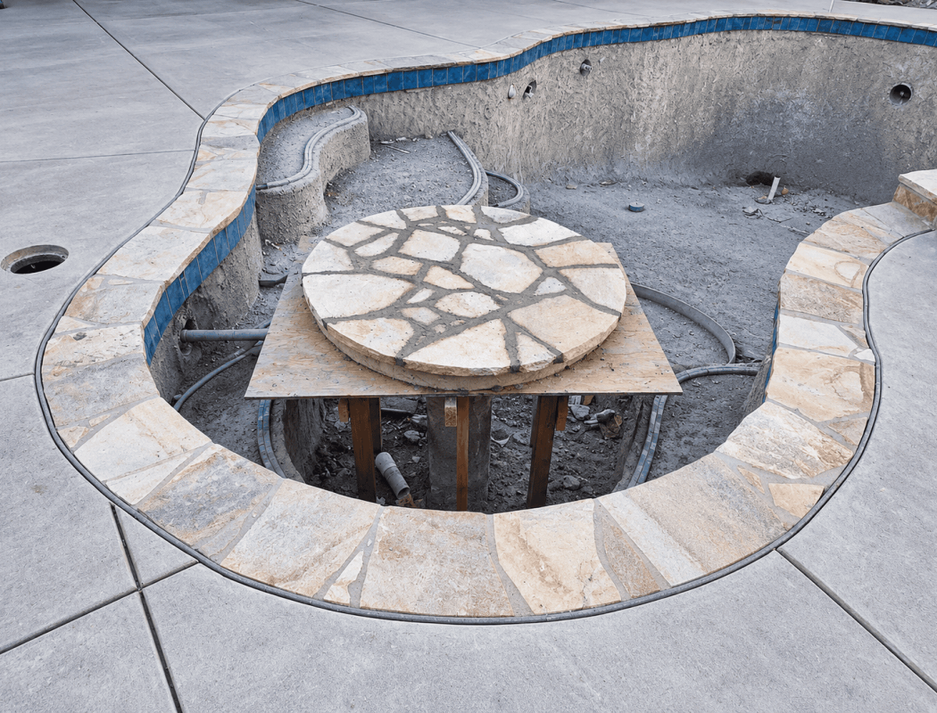 In-progress pool renovation with stone coping and interior surface.