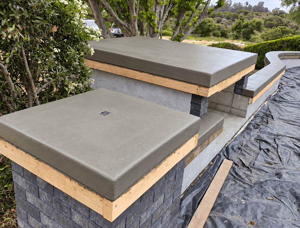 Modern concrete bench and wall with brick base in outdoor setting.