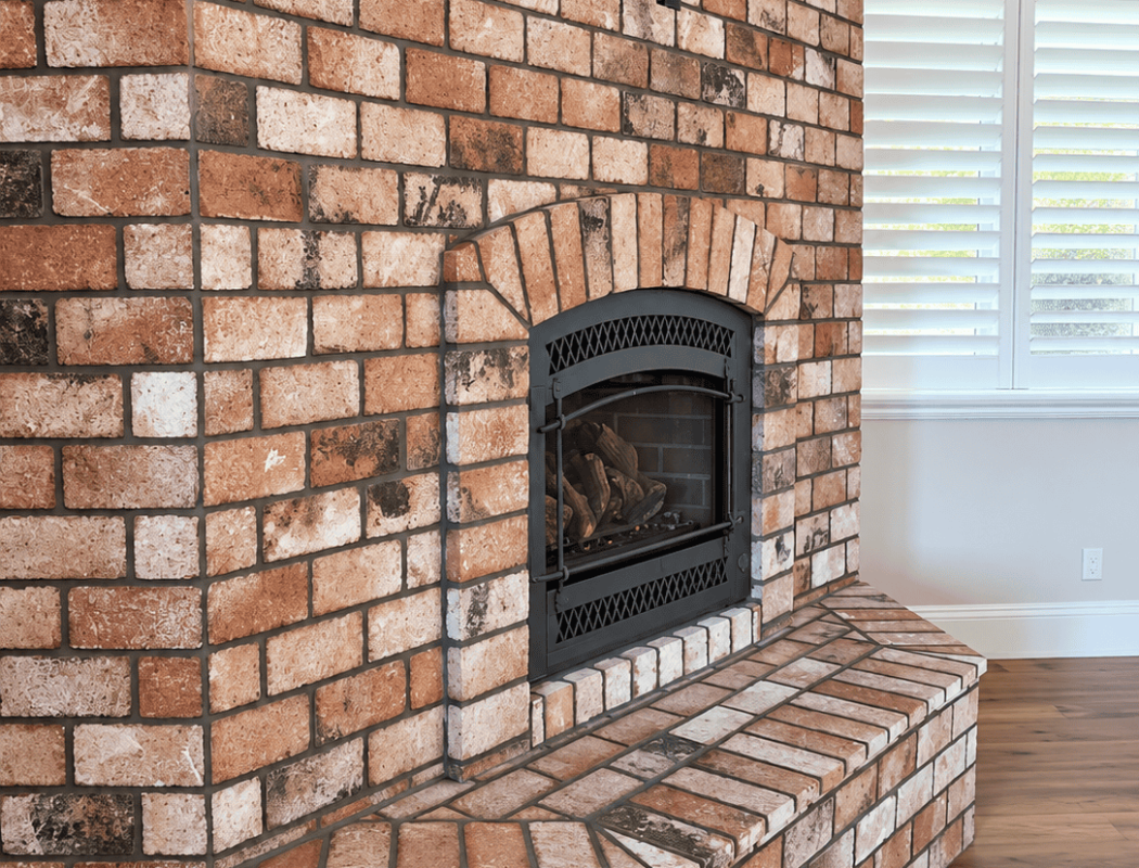 Brick fireplace with a wood-burning insert in a modern living room.