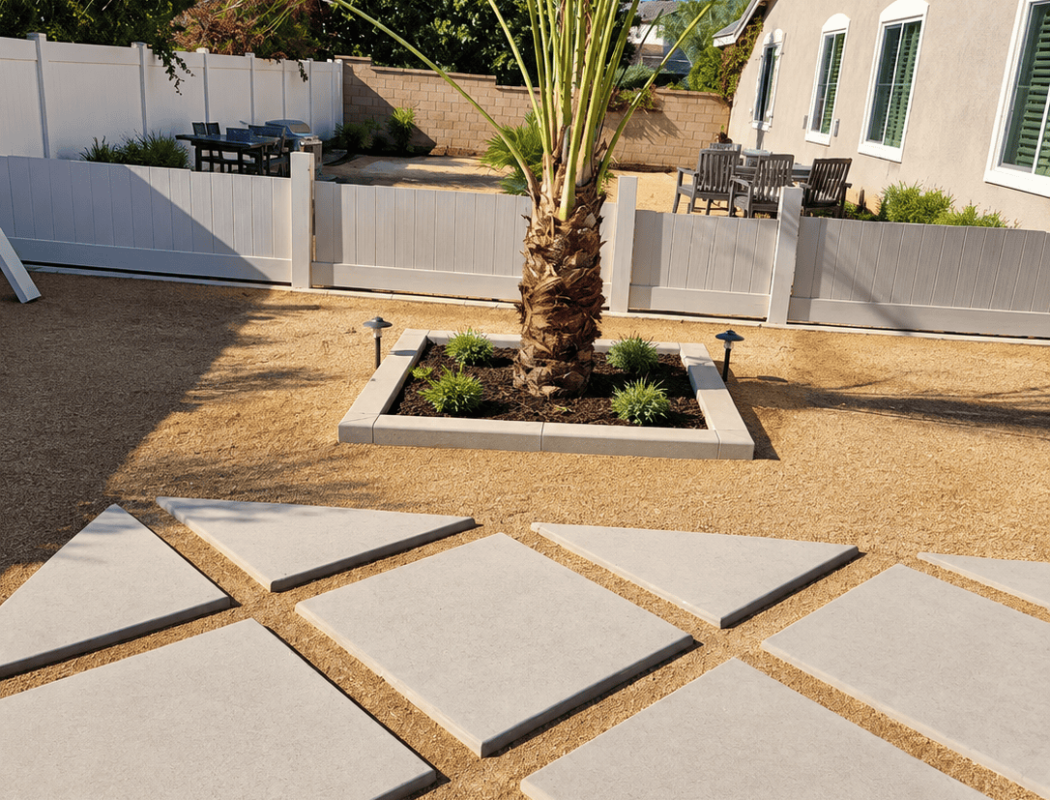 Concrete patio with large stepping stones and palm tree in backyard.